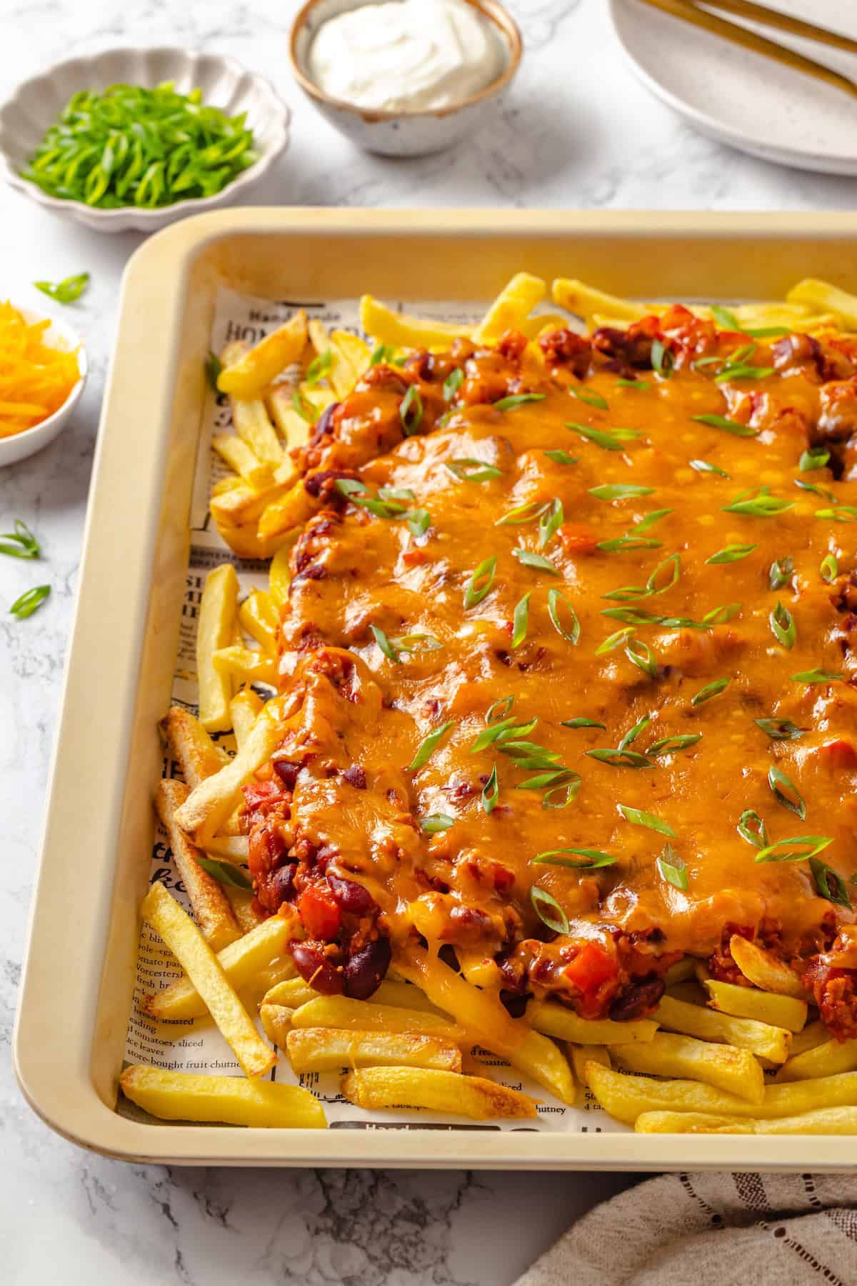 Chili cheese fries on baking tray.