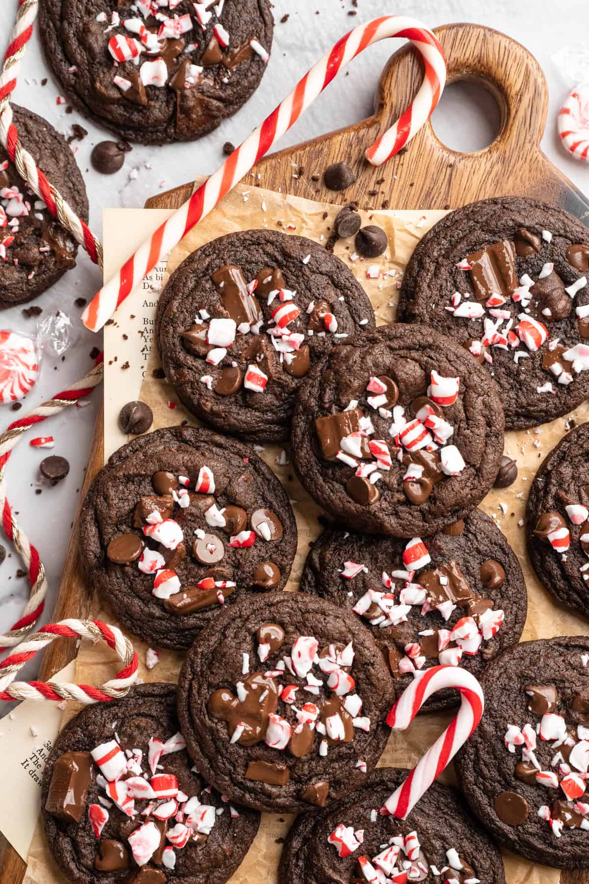 Pile of chewy peppermint chocolate cookies on wooden board.