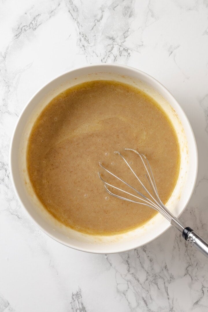 This vegan coffee cake recipe is a bakery-style treat! Moist and tender, with a cinnamon swirl and irresistible crumb topping. Delicious! Whisk in bowl of wet ingredients.