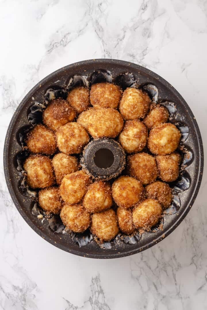 Soft, gooey and sticky, this Vegan Monkey Bread recipe is an irresistible pull-apart treat that's perfect for weekend brunches and holidays! Monkey bread in pan before second rise.