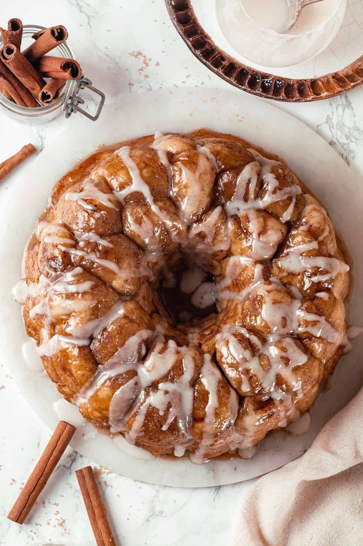 Soft, gooey and sticky, this Vegan Monkey Bread recipe is an irresistible pull-apart treat that's perfect for weekend brunches and holidays! Glazed monkey bread on marble board.