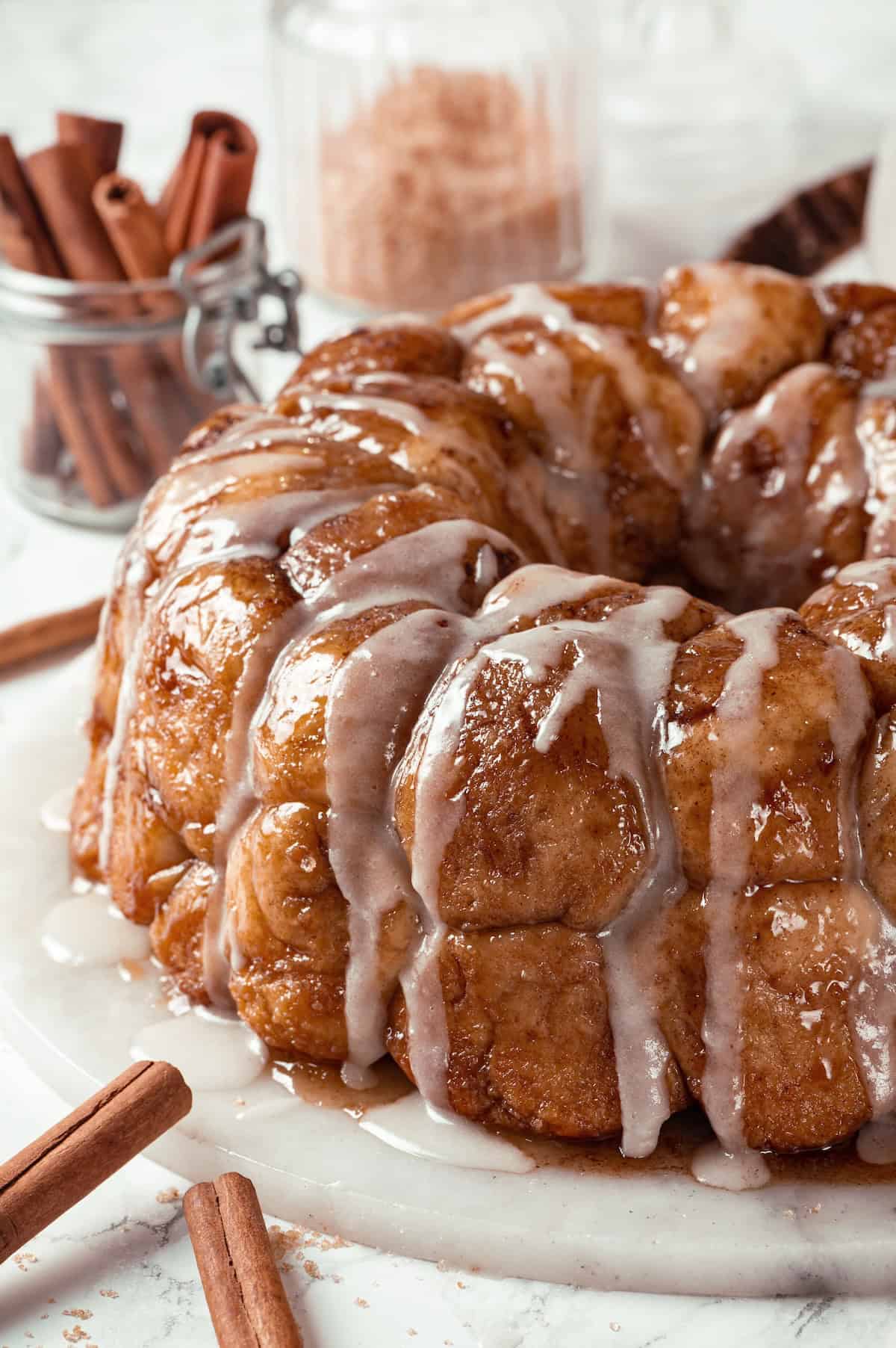 Soft, gooey and sticky, this Vegan Monkey Bread recipe is an irresistible pull-apart treat that's perfect for weekend brunches and holidays! Glazed monkey bread on marble platter.