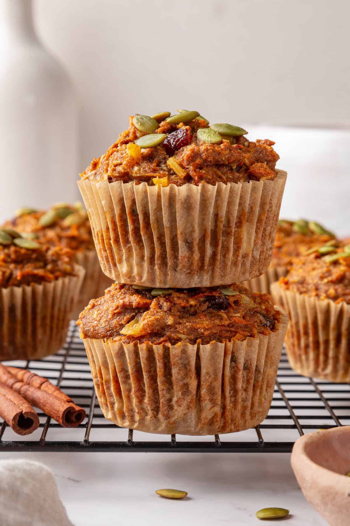 With cozy spices, carrots, pineapple, and apple, along with a nutty crunch, these vegan morning glory muffins are super moist and so delish! Stack of 2 vegan morning glory muffins.