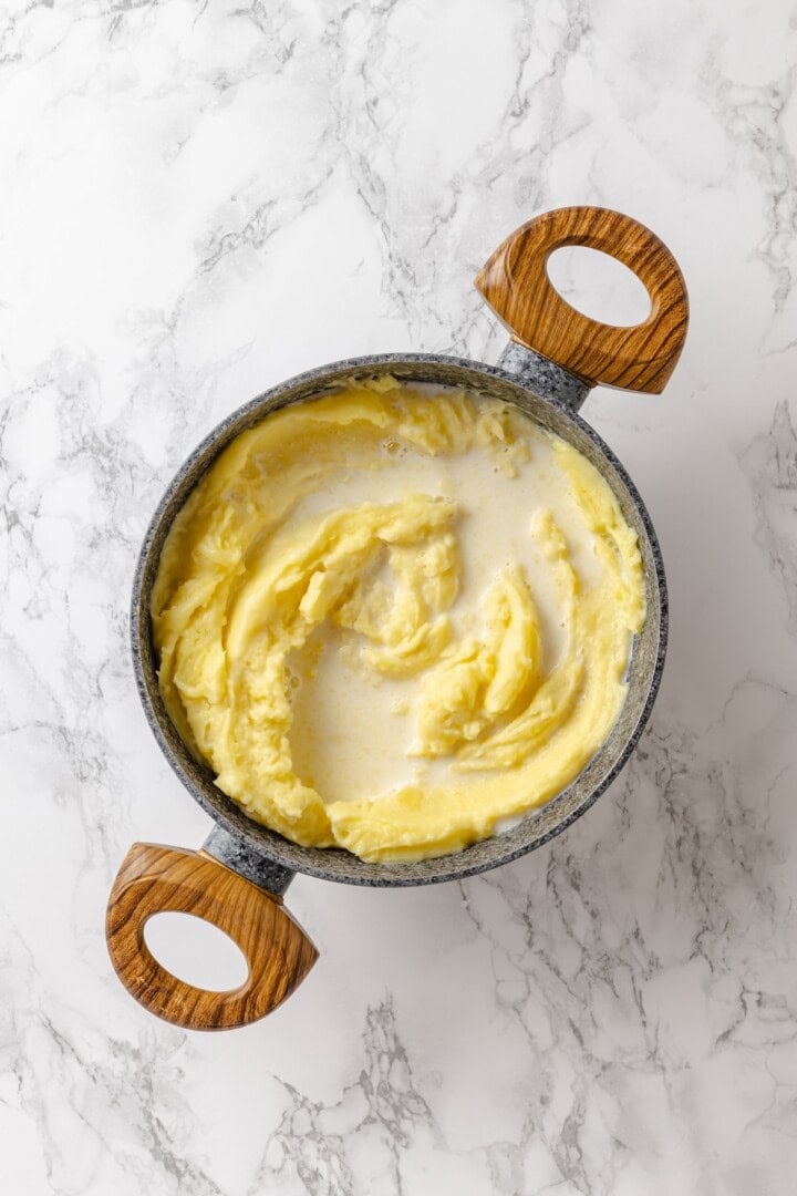 This vegan pierogi casserole layers a cheesy potato filling with lasagna noodles for pierogi vibes without the work of making dumplings! Vegan milk added to pot of mashed potatoes.