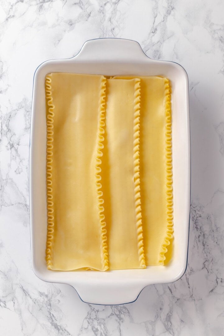 This vegan pierogi casserole layers a cheesy potato filling with lasagna noodles for pierogi vibes without the work of making dumplings! Lasagna noodles in casserole dish.