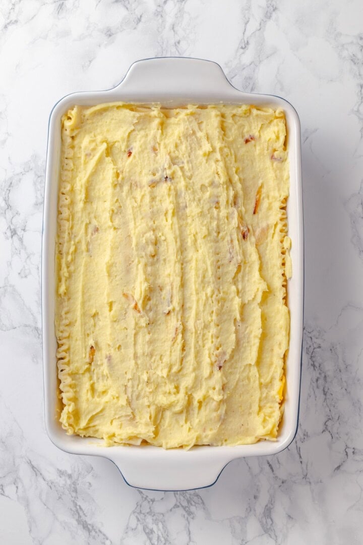 This vegan pierogi casserole layers a cheesy potato filling with lasagna noodles for pierogi vibes without the work of making dumplings! Mashed potatoes spread into casserole dish over lasagna noodles.