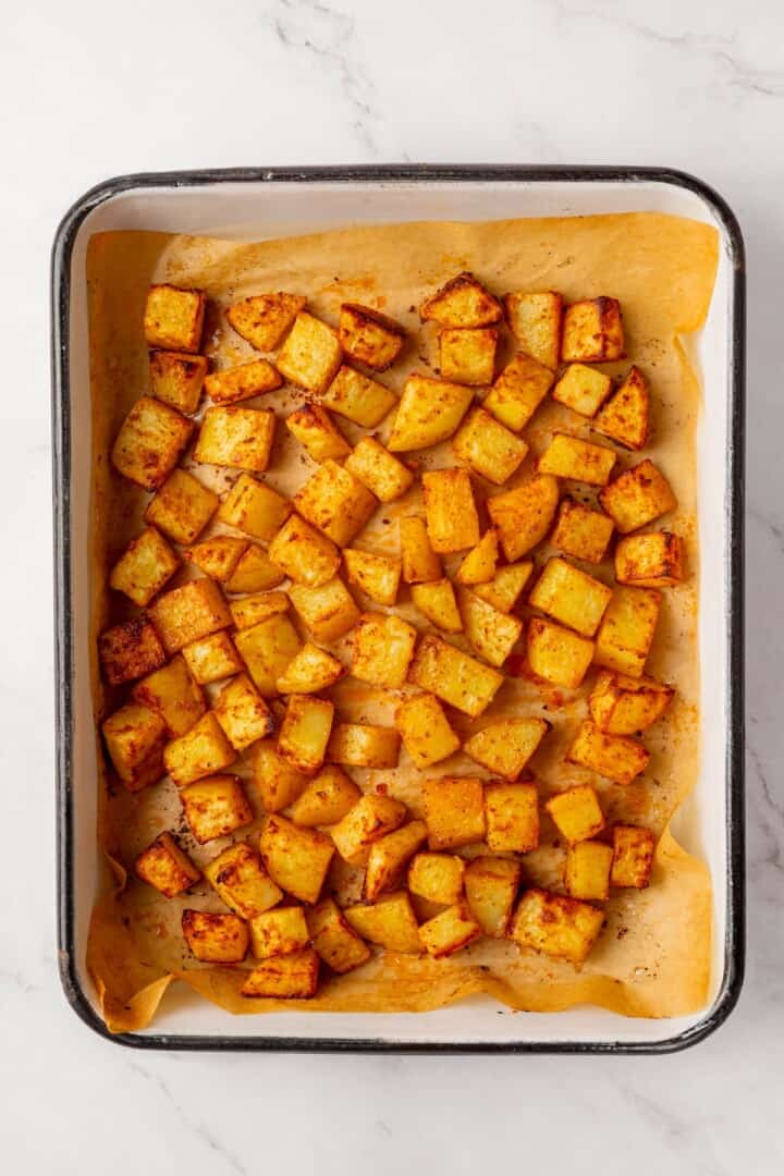 These copycat Taco Bell vegan spicy potato soft tacos are even better than the original. Crispy potatoes and creamy sauce make them so tasty! Roasted seasoned potatoes in parchment lined pan.