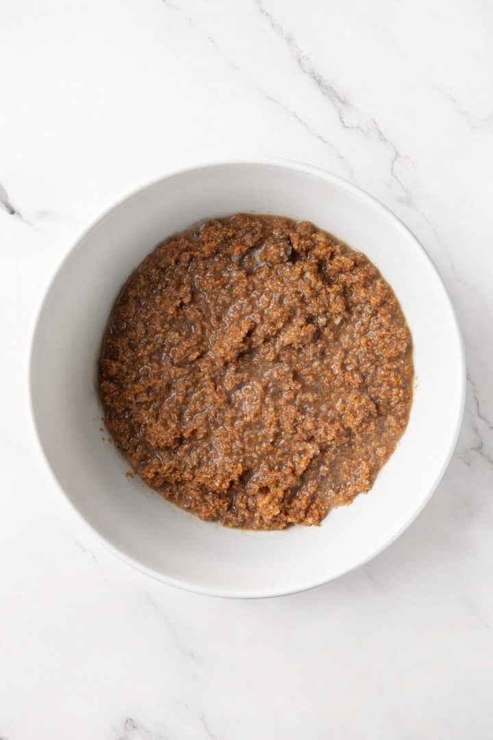 This moist vegan bran muffin recipe is made with whole wheat flour, raisins, and spiced with cinnamon for an easy, wholesome breakfast! Wet ingredients for bran muffins in bowl.