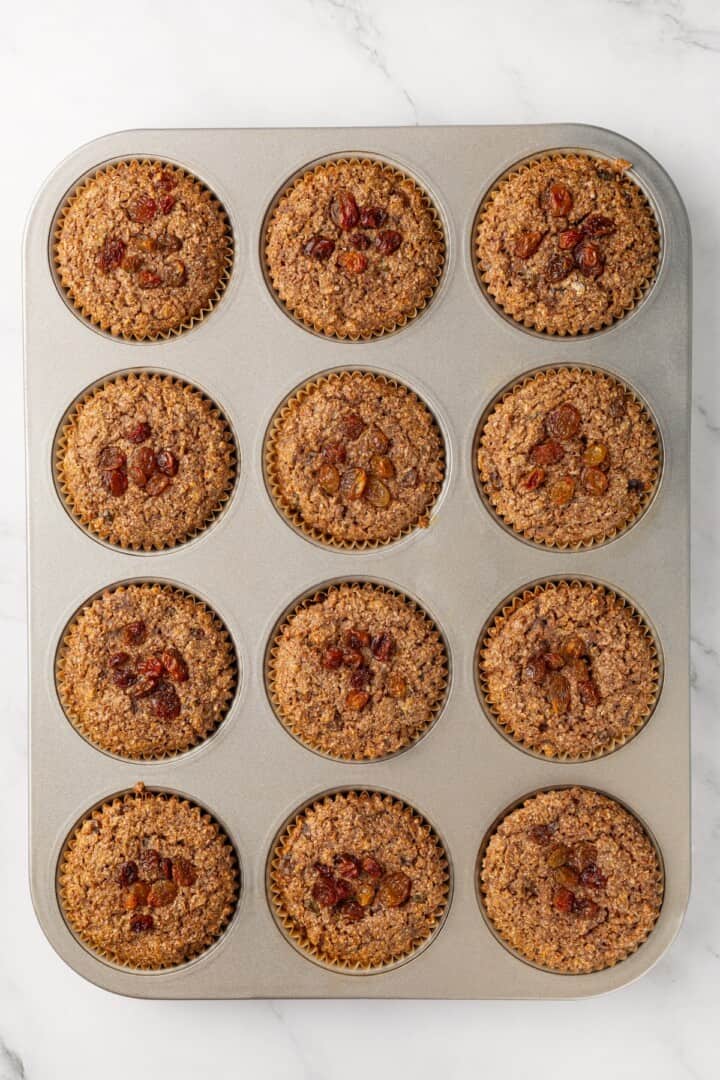 This moist vegan bran muffin recipe is made with whole wheat flour, raisins, and spiced with cinnamon for an easy, wholesome breakfast! Cinnamon raisin bran muffins in pan.