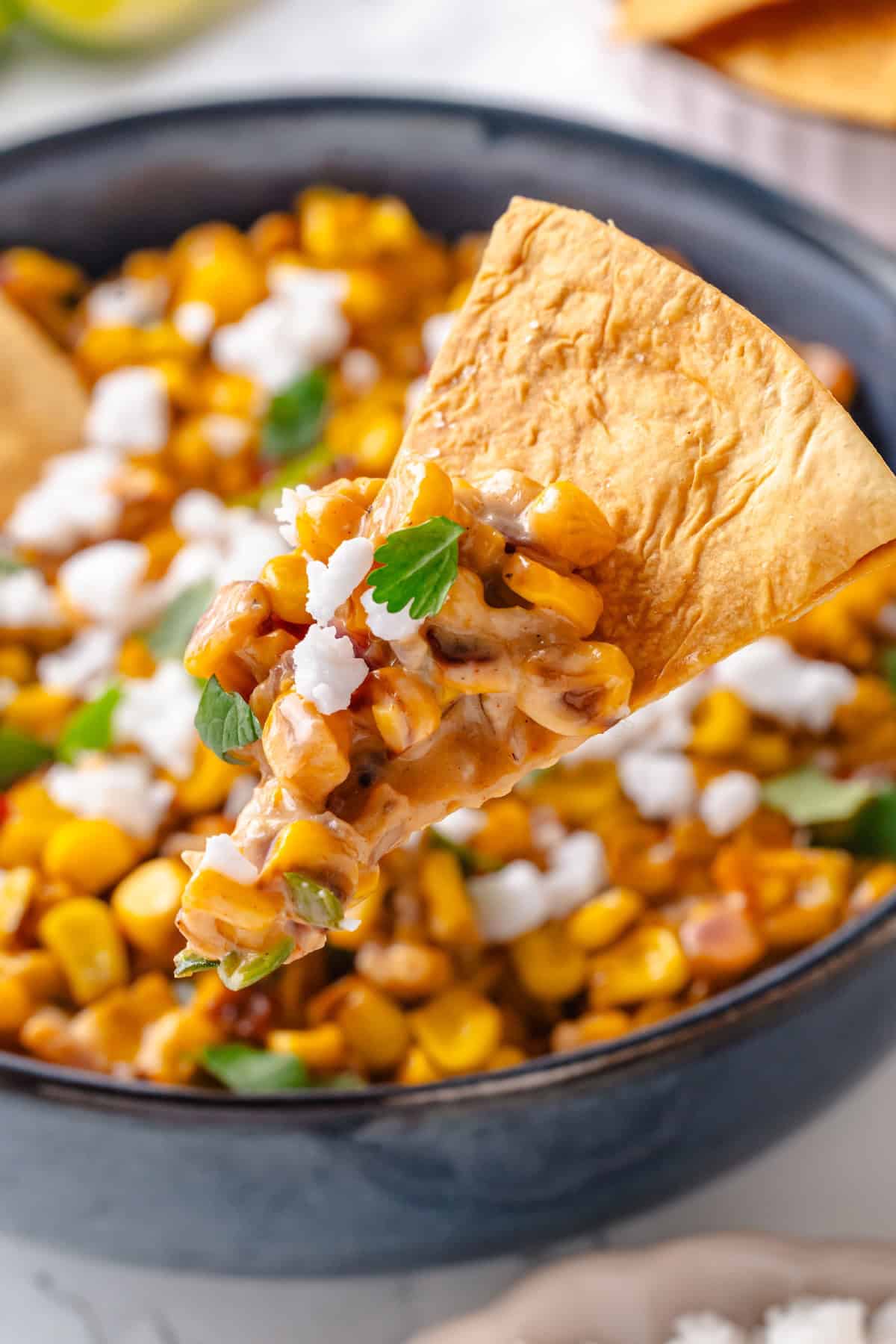 This vegan Mexican Street Corn Dip is creamy, smoky, and a little bit spicy (just like elotes!) for an easy appetizer everyone will love! Mexican street corn dip on tortilla chip.