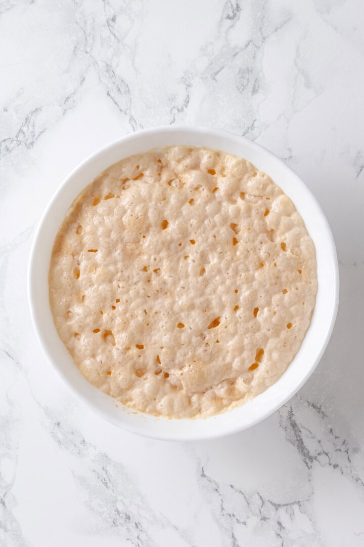 This vegan Moravian sugar cake recipe is made with a soft yeasted potato dough and buttery cinnamon sugar topping. Perfect for brunch! Foamy yeast mixture in bowl.