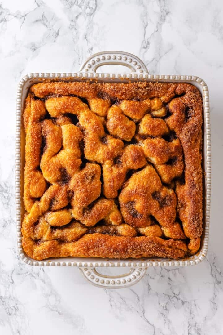 This vegan Moravian sugar cake recipe is made with a soft yeasted potato dough and buttery cinnamon sugar topping. Perfect for brunch! Baked Moravian sugar cake in dish.