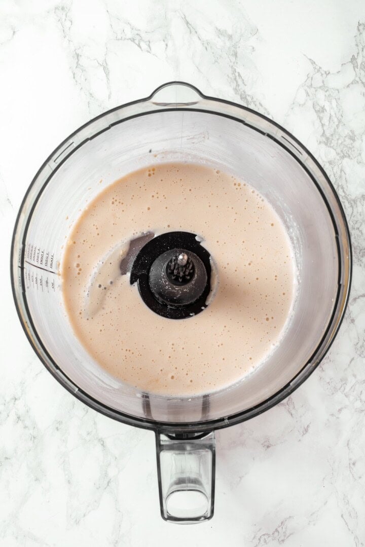 This easy vegan salami recipe is smoky, savoury and sliceable, just like the real deal! Perfect for sandwiches and charcuterie boards. Liquid ingredients for vegan salami in food processor.