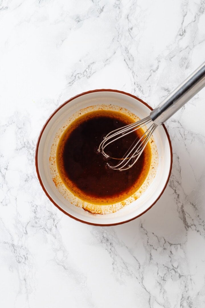 This cowboy caviar recipe is made with black-eyed peas, black beans, avocado, veggies, and a zesty dressing. Use it as a dip or a side dish! Whisk in bowl of red wine vinaigrette.