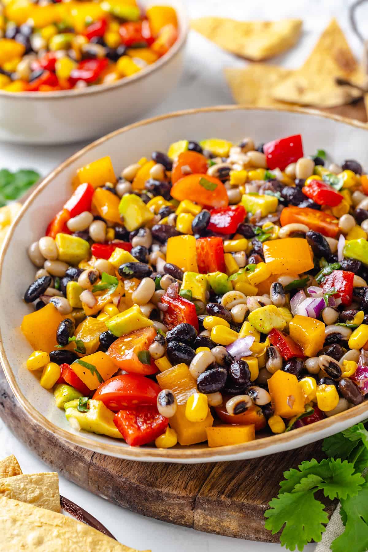 This cowboy caviar recipe is made with black-eyed peas, black beans, avocado, veggies, and a zesty dressing. Use it as a dip or a side dish! Bowl of cowboy caviar.
