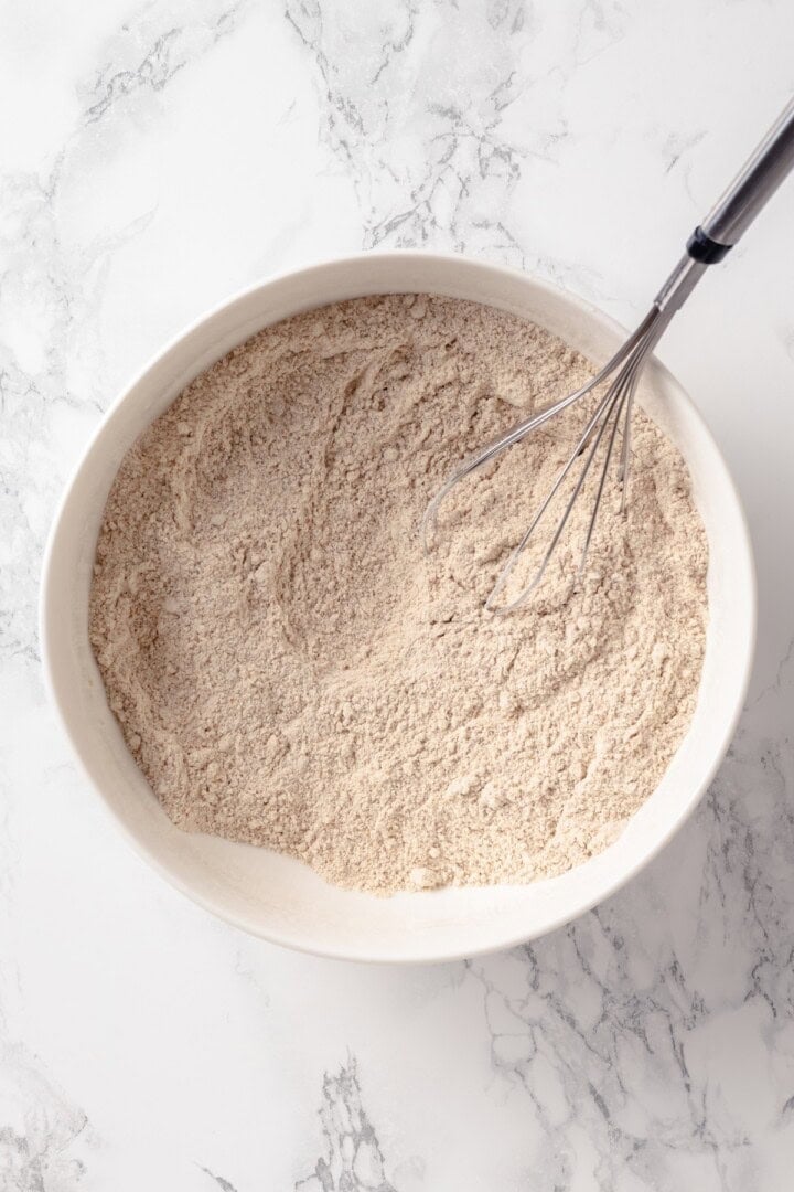 These moist peanut butter banana muffins are made with whole wheat flour and chocolate chips for a wholesome muffin that tastes like a treat! Dry ingredients in mixing bowl with whisk.