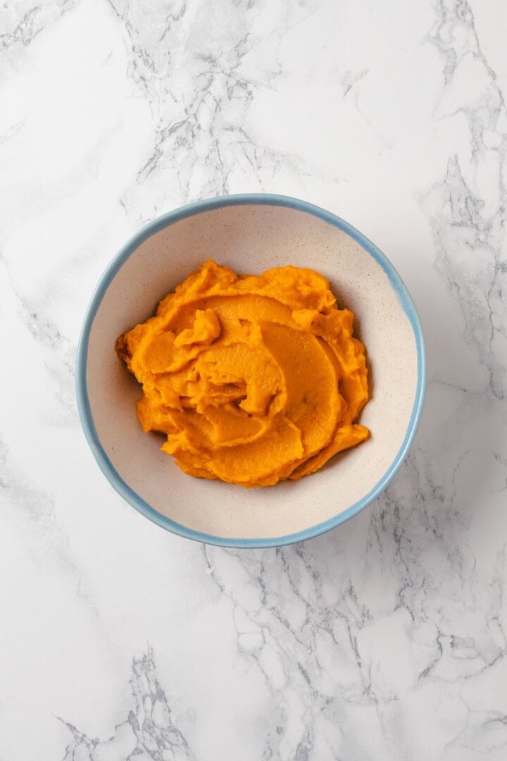 These fudgy vegan sweet potato brownies are made with maple syrup and cocoa for a treat that’s naturally sweet, gluten-free, and oh so rich! Sweet potato puree in bowl.