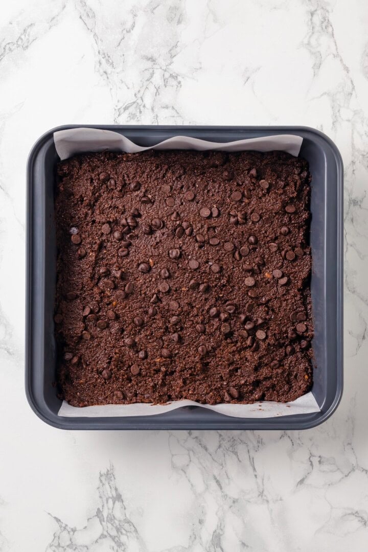 These fudgy vegan sweet potato brownies are made with maple syrup and cocoa for a treat that’s naturally sweet, gluten-free, and oh so rich! Unbaked sweet potato brownies in pan.