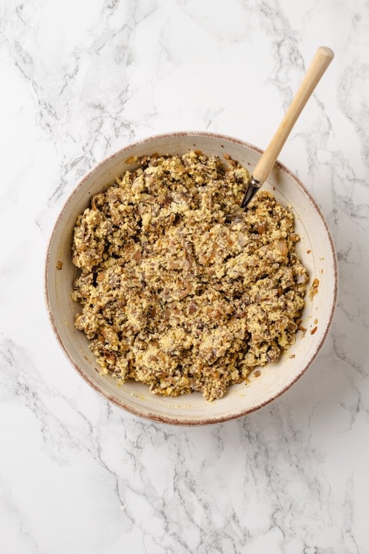 This homemade mushroom ravioli is filled with porcini, cremini and ricotta, then tossed in a creamy vegan Parmesan sauce. Restaurant-worthy! Mushroom ricotta filling in bowl.