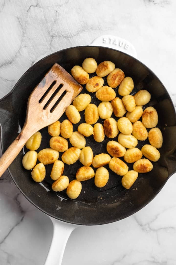 This one pot cheesy tomato gnocchi is creamy, comforting, and ready in under 30 minutes for an easy vegan weeknight dinner! Toasted gnocchi in skillet.