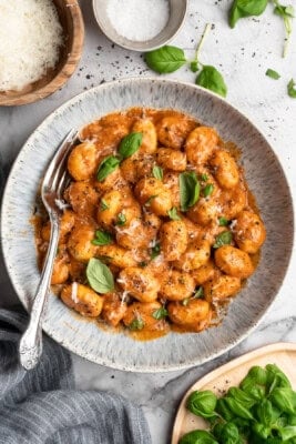 Bowl of one pot cheesy tomato gnocchi with basil.