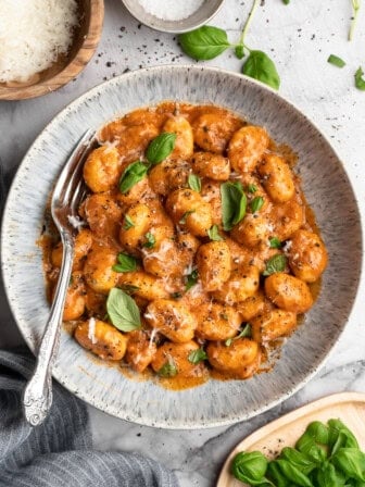 Bowl of one pot cheesy tomato gnocchi with basil.
