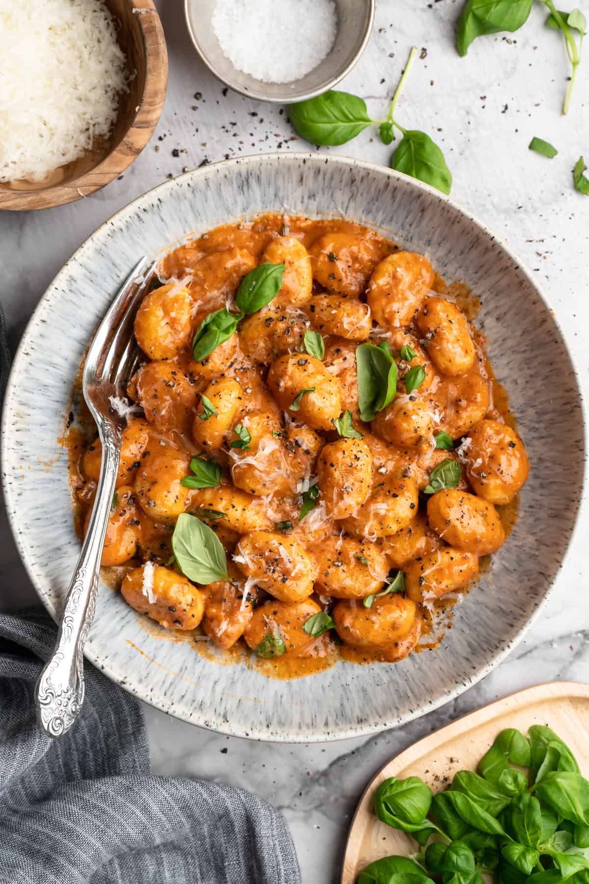 This one pot cheesy tomato gnocchi is creamy, comforting, and ready in under 30 minutes for an easy vegan weeknight dinner! Bowl of one pot cheesy tomato gnocchi with basil.