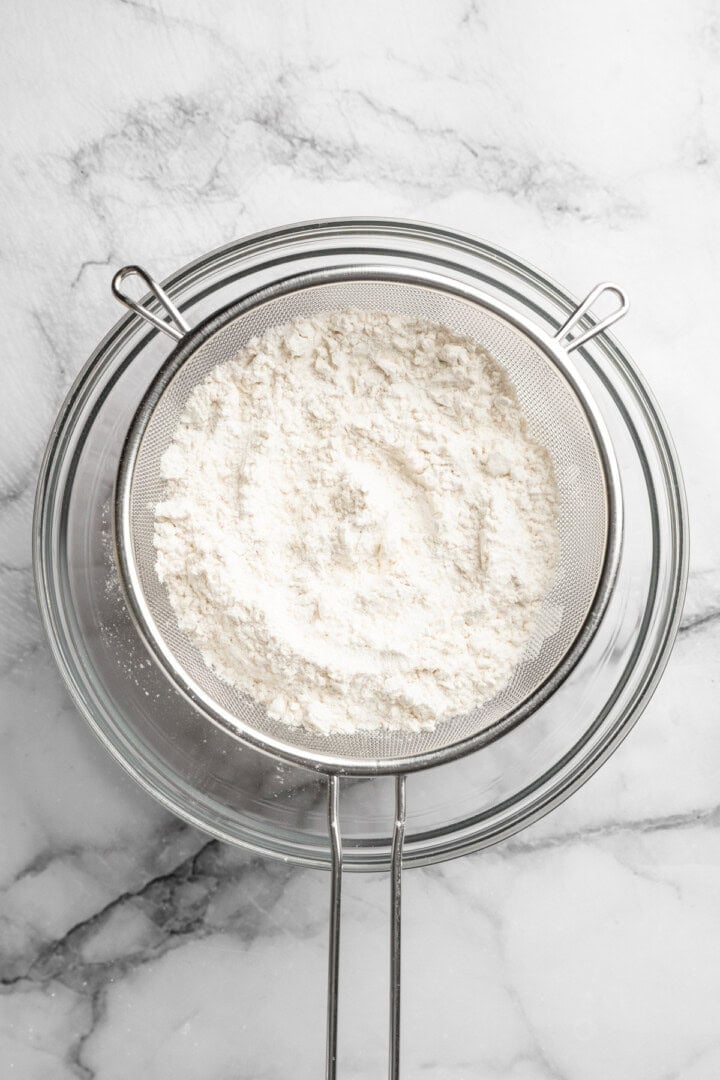 These fluffy sheet pan pancakes bake in one pan for an easy, no-flip breakfast that’s perfect for busy mornings or brunch. Sifting dry ingredients through colander into bowl.