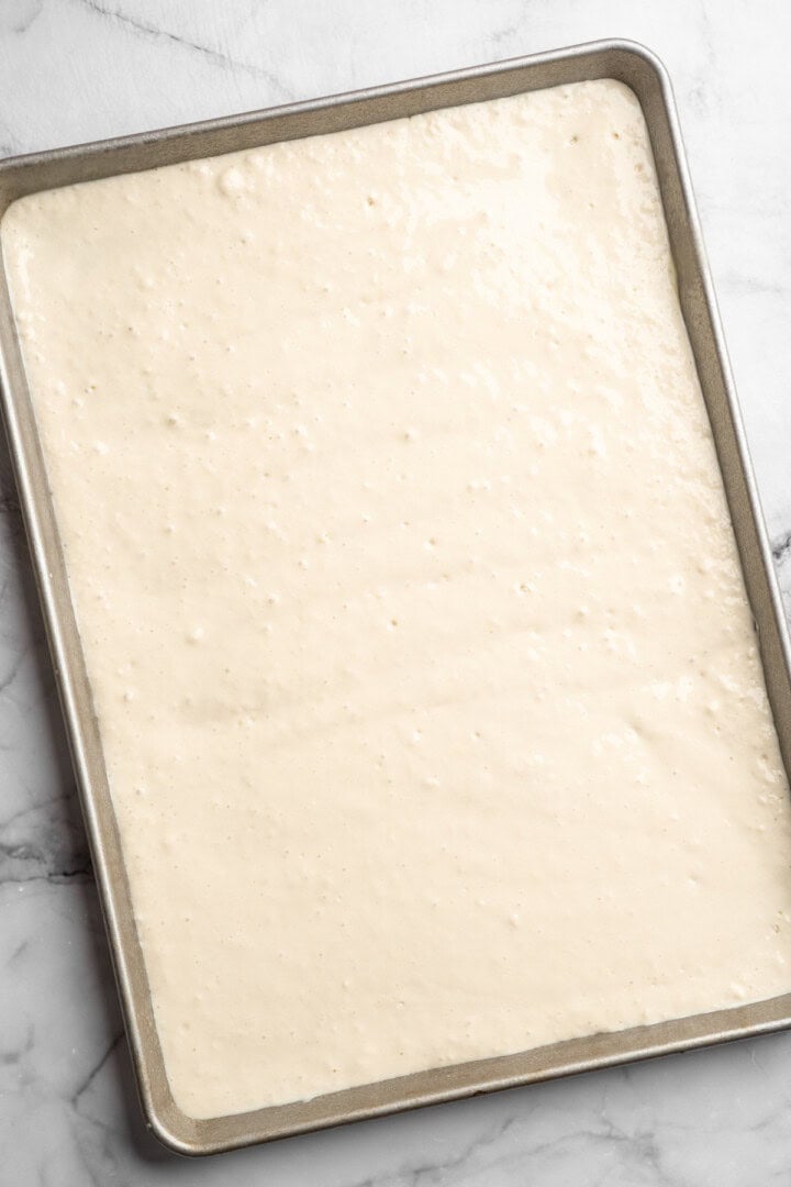 These fluffy sheet pan pancakes bake in one pan for an easy, no-flip breakfast that’s perfect for busy mornings or brunch. Batter in pan for sheet pan pancakes.