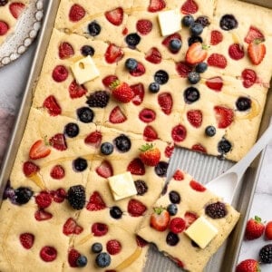 Pan of sliced sheet pan pancakes with berries.