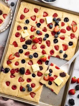 Pan of sliced sheet pan pancakes with berries.