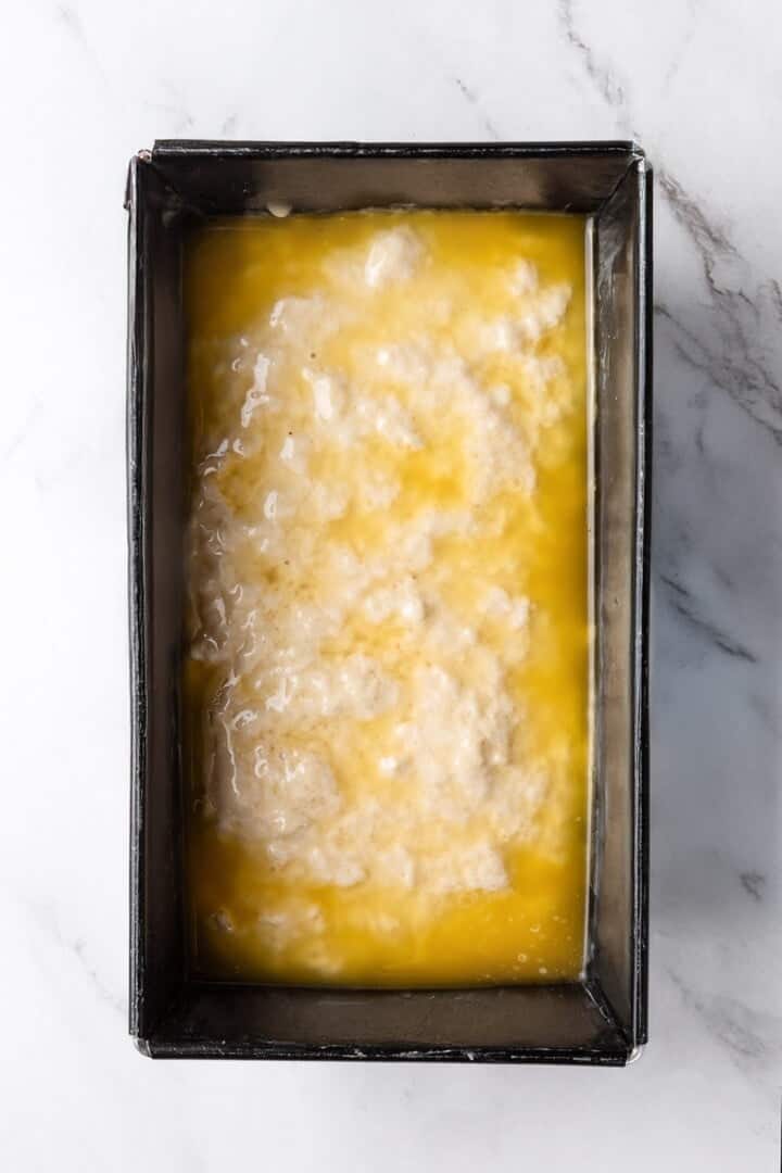 This easy beer bread recipe is soft, moist and baked with a crisp golden crust. It’s a simple no-knead loaf ready to eat in under an hour! Beer bread batter in pan topped with melted butter.