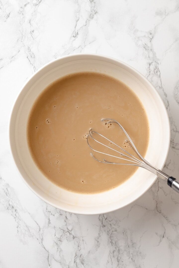 German pancakes bake up puffy and golden with crisp edges and a tender middle. Aquafaba stands in for the eggs in this easy vegan recipe! Whisk in bowl of wet ingredients for German pancakes.