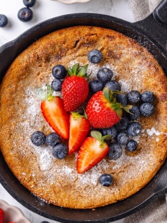 German pancake topped with blueberries and strawberries.
