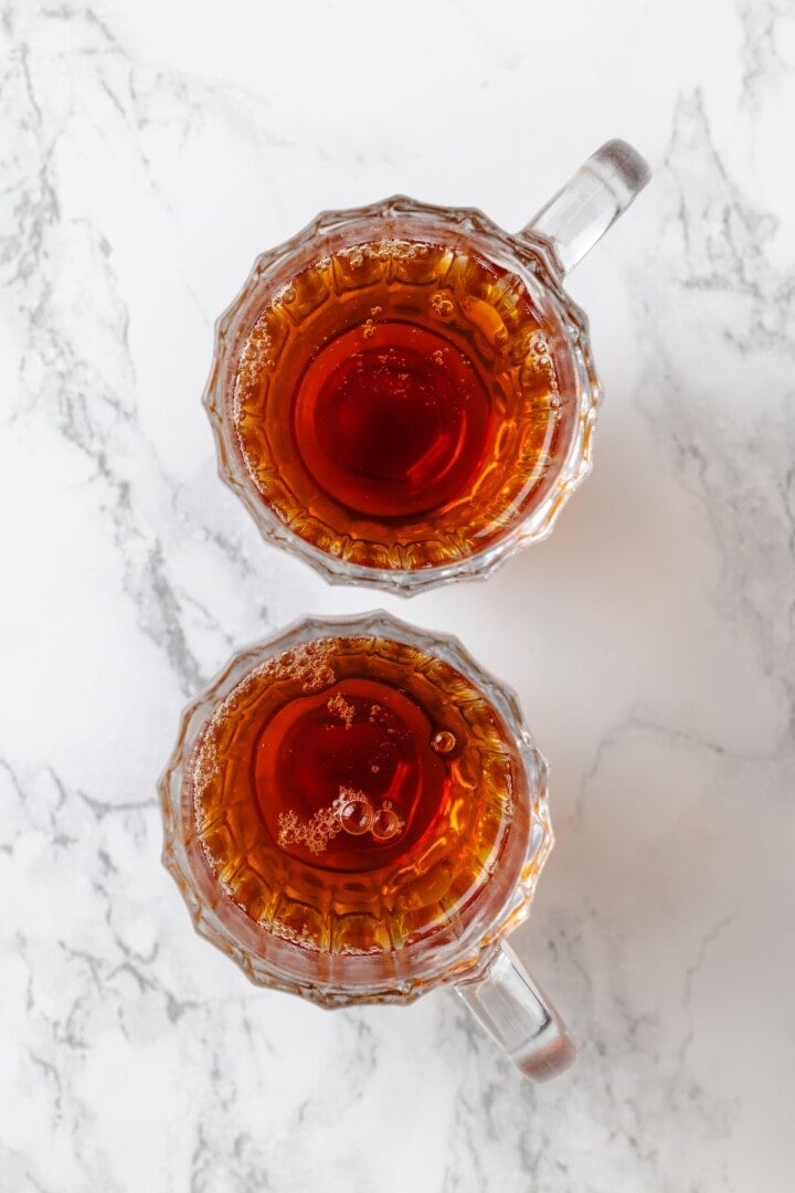 This cozy London Fog recipe blends fragrant Earl Grey tea, vanilla and creamy vegan milk into a sweet café-style latte you can make at home! Earl Grey tea in two glass mugs.