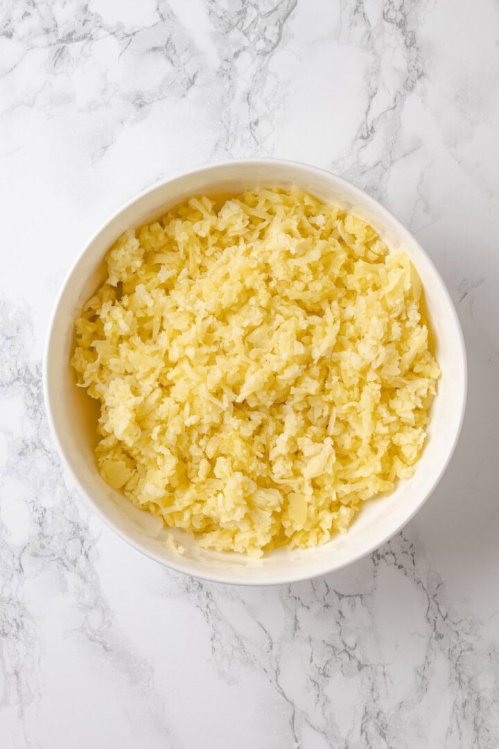 These homemade tater tots are crispy outside, fluffy inside and made with real potatoes. Bake, fry, air fry or freeze them for later! Mashed potatoes in bowl.