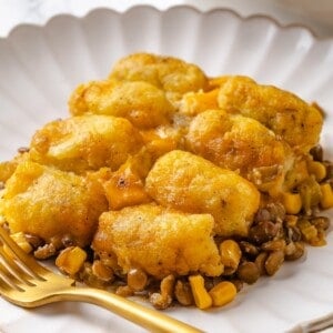 Portion of vegan tater tot casserole on plate with fork.