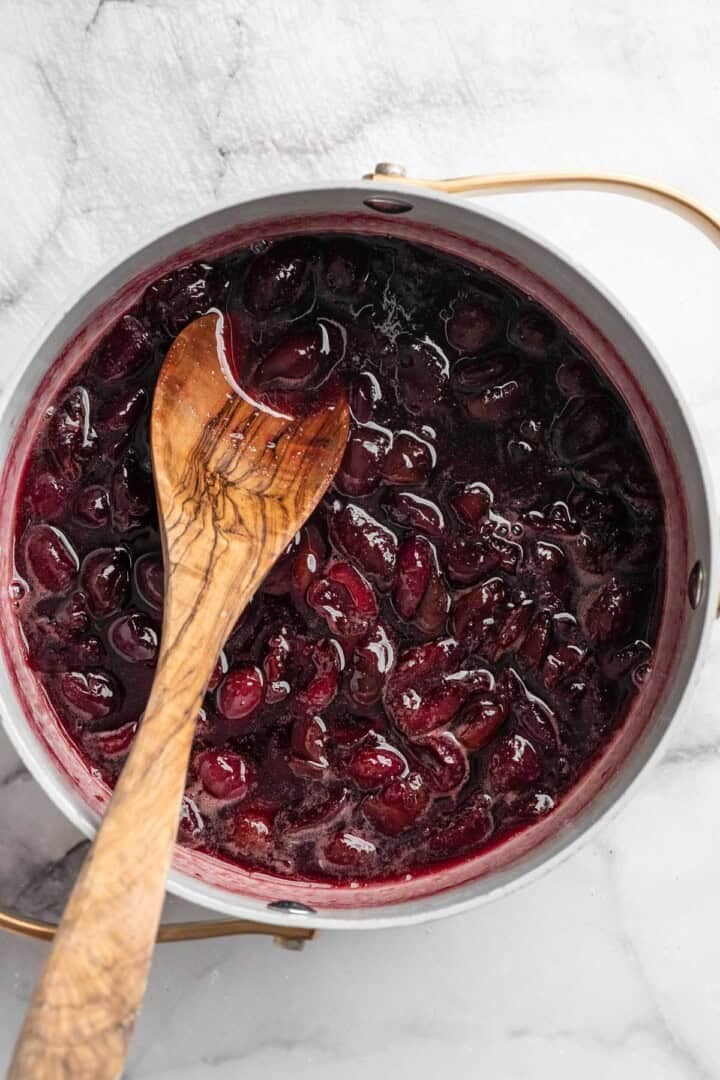 Stirring cherries and syrup in pan.