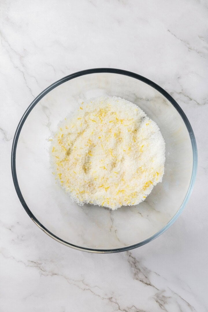 These vegan lemon crinkle cookies bake up soft and chewy, with a sunny citrus flavour and a classic powdered sugar crackle on top. Lovely! Lemon zest and sugar in bowl.