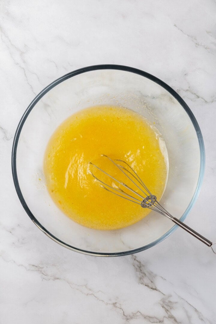 These vegan lemon crinkle cookies bake up soft and chewy, with a sunny citrus flavour and a classic powdered sugar crackle on top. Lovely! Whisking wet ingredients in glass mixing bowl.