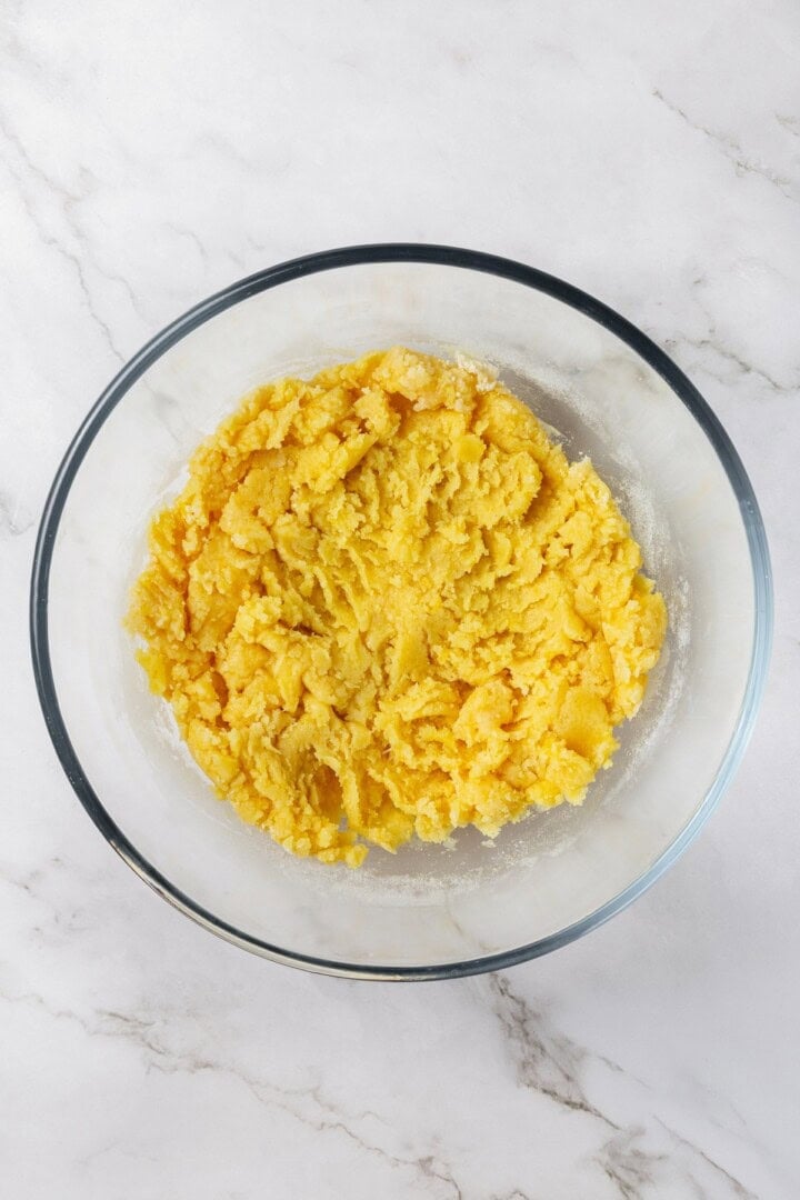 These vegan lemon crinkle cookies bake up soft and chewy, with a sunny citrus flavour and a classic powdered sugar crackle on top. Lovely! Lemon crinkle cookie dough in glass bowl.
