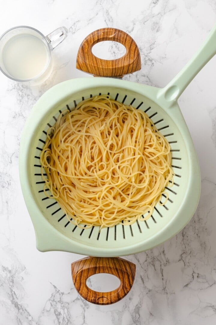 These vegan garlic noodles deliver bold, buttery garlic flavour in a quick, satisfying dish that’s ready in just 20 minutes! Angel hair noodles in colander.