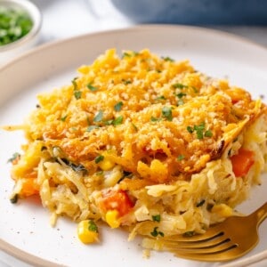 Serving of vegan hashbrown casserole on plate with fork.