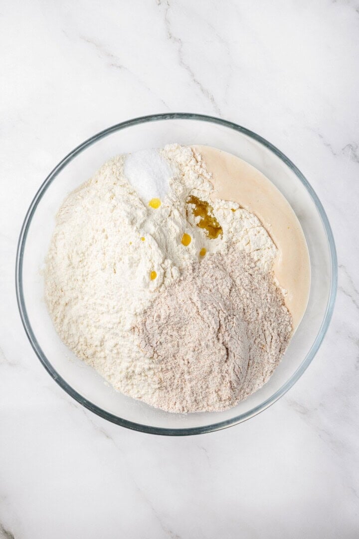 Tender and warm, with a perfect pocket in the middle, this easy homemade pita bread recipe gives your wraps, dips and sandwiches an upgrade! Ingredients for pita bread dough in bowl.