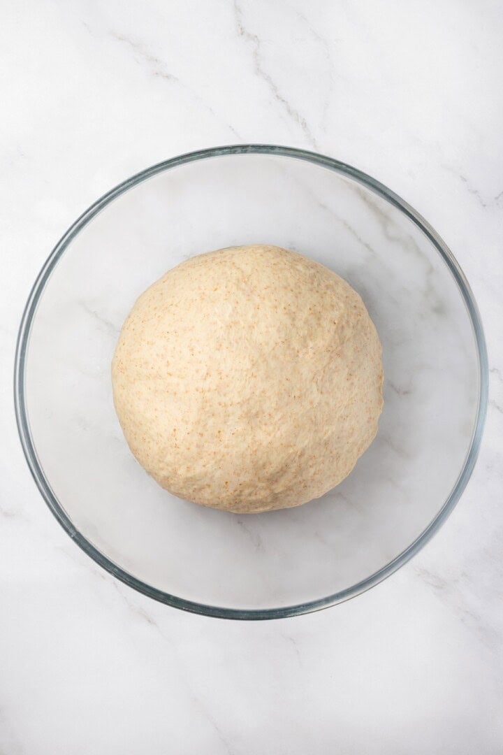 Tender and warm, with a perfect pocket in the middle, this easy homemade pita bread recipe gives your wraps, dips and sandwiches an upgrade! Pita bread dough in bowl before rising.