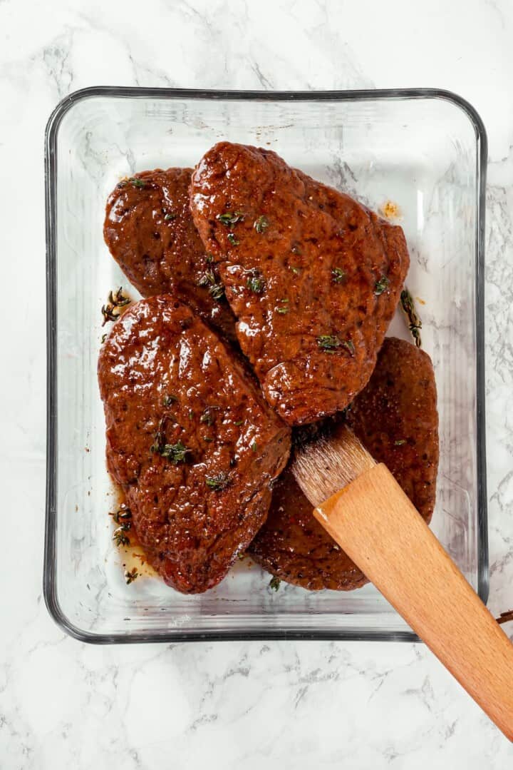 Savory, hearty and full of umami flavor, this homemade vegan steak is made with seitan for a protein-packed plant-based main dish! Brushing vegan steaks with marinade.