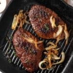 Vegan steak in grill pan with onions.