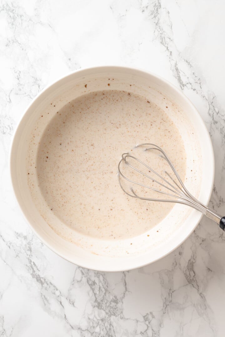 Golden, custardy, and filled with jammy berries and vanilla cream cheese, this vegan stuffed French toast turns brunch into something special! Whisking vegan custard in bowl.