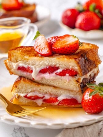 Plate of stuffed French toast with strawberries and cream cheese.