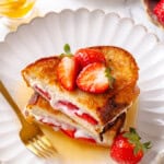 Plate of strawberry and cream cheese French toast with maple syrup.